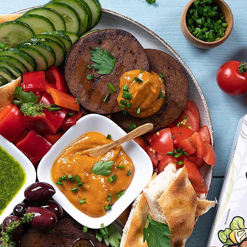 Sommerliche Mezze Platte mit Seitan, veganer Erdnuss Sauce und grüne Kräuter Pesto